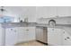 Modern kitchen with stainless steel appliances, white cabinets, and gray countertops, open to the living area at 200 Cimarron Dr, Kissimmee, FL 34759