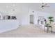 Open-concept living area featuring neutral tones, carpet flooring, and seamless transitions to the kitchen and dining areas at 200 Cimarron Dr, Kissimmee, FL 34759