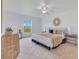 Well-lit main bedroom features ceiling fan, neutral colors, and tasteful decor, with a view of the outside at 200 Cimarron Dr, Kissimmee, FL 34759