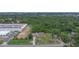 Aerial view of a residential property with a pool near a warehouse and rows of tree greenhouses in the neighborhood at 2112 Plymouth Sorrento Rd, Apopka, FL 32712