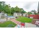 A quaint backyard featuring an above-ground pool, sheds, and brick-lined patio with dining set at 2112 Plymouth Sorrento Rd, Apopka, FL 32712