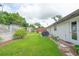 Green backyard featuring a small patio area, lush grass, and various plants at 2112 Plymouth Sorrento Rd, Apopka, FL 32712