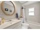 Neutral-toned bathroom featuring a white vanity, framed mirror, and bathtub and shower at 2112 Plymouth Sorrento Rd, Apopka, FL 32712