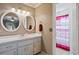 Bright bathroom featuring a double vanity, round mirrors, and a separate toilet and shower area at 2112 Plymouth Sorrento Rd, Apopka, FL 32712