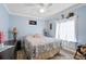 Light blue bedroom with a floral comforter, matching lamps, decor, and natural light through the window at 2112 Plymouth Sorrento Rd, Apopka, FL 32712