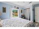 This light blue bedroom features a window overlooking the backyard and a closet at 2112 Plymouth Sorrento Rd, Apopka, FL 32712