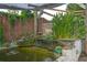 Beautiful Koi pond with tiered waterfall, wooden pergola, and lush plantings at 2112 Plymouth Sorrento Rd, Apopka, FL 32712