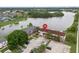 Aerial view of a property by the lake, featuring ample parking and mature trees at 214 Majors Ln # B, Kissimmee, FL 34743