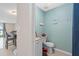Half bathroom with a toilet, a sink with white cabinets, light-blue walls, and decor at 214 Majors Ln # B, Kissimmee, FL 34743