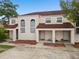 Exterior of a townhouse with a red roof and a covered porch and green lawn at 214 Majors Ln # B, Kissimmee, FL 34743