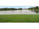 Scenic lake view featuring a grassy shoreline and mature trees, providing a serene natural backdrop at 214 Majors Ln # B, Kissimmee, FL 34743