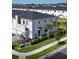 Aerial view of modern townhome community with well-manicured lawns, lush landscaping, and a contemporary architectural design at 224 Nine Iron Dr, Davenport, FL 33896