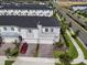 An aerial perspective reveals a modern townhome neighborhood, showcasing neat landscaping, contemporary architecture, and a red car at 224 Nine Iron Dr, Davenport, FL 33896