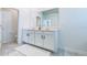 Bathroom with double vanity and white cabinets, gray tile, and framed mirror at 224 Nine Iron Dr, Davenport, FL 33896
