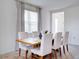 Bright dining room features a wooden table, white chairs, and a decorative rug for a cozy feel at 224 Nine Iron Dr, Davenport, FL 33896