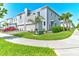 Modern townhome with a two-car garage, stone accents, lush landscaping, and a red car parked in driveway at 224 Nine Iron Dr, Davenport, FL 33896