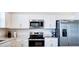 Modern kitchen featuring stainless steel appliances, white cabinetry, and a sleek countertop at 224 Nine Iron Dr, Davenport, FL 33896