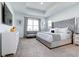 Spacious main bedroom with a tray ceiling, a large window, and a stylish gray upholstered bed at 224 Nine Iron Dr, Davenport, FL 33896
