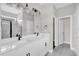 Elegant bathroom featuring double sinks, a large mirror, modern lighting, and a walk-in shower at 2311 Bear Peak Rd, Clermont, FL 34715