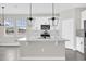 Bright kitchen featuring a center island, white cabinets, pendant lighting, and stainless appliances at 2311 Bear Peak Rd, Clermont, FL 34715