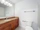 Bathroom showcases wood vanity, granite countertop, large mirror, and towel racks at 2580 Grassy Point Dr # 106, Lake Mary, FL 32746