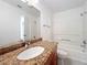 Bathroom featuring granite countertops, white sink, and shower/bath combo at 2580 Grassy Point Dr # 106, Lake Mary, FL 32746