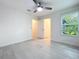 Bedroom featuring modern tile floors, a ceiling fan, and window overlooking lush greenery at 2580 Grassy Point Dr # 106, Lake Mary, FL 32746