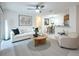 Bright, open-concept living room featuring a modern sofa, ceiling fan, and adjacent dining area at 2580 Grassy Point Dr # 106, Lake Mary, FL 32746