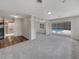 Open living room featuring gray carpet, built-in shelving, and sliding glass doors to the pool area at 2710 Wyndham Ln, Orlando, FL 32808