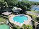 Aerial view of a community pool with lounge chairs and a clubhouse surrounded by lush trees at 2922 Burlington Dr, Apopka, FL 32703