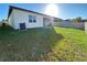 Well-maintained backyard with healthy green grass, a white fence, and a view of the home's exterior at 312 Irving Bend Dr, Groveland, FL 34736