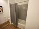 Cozy bathroom featuring a bathtub with a shower curtain and wood-style flooring at 312 Irving Bend Dr, Groveland, FL 34736