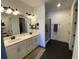 Modern bathroom featuring double sinks, white cabinets, and a separate glass shower at 312 Irving Bend Dr, Groveland, FL 34736