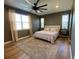 Well-lit bedroom features a large ceiling fan, wood floors, and stylish area rug at 312 Irving Bend Dr, Groveland, FL 34736