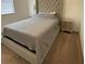 Bedroom features a tufted headboard, bedside tables, and a cozy gray comforter at 312 Irving Bend Dr, Groveland, FL 34736