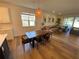 Open concept living/dining room features a wooden dining table, modern light fixture, and hardwood floors at 312 Irving Bend Dr, Groveland, FL 34736