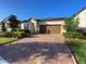 Charming single-story home with a well-maintained lawn and brick paved driveway leading to a two-car garage at 312 Irving Bend Dr, Groveland, FL 34736