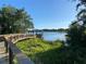 Scenic view of a wooden gazebo by a lake, accessible by a wooden walkway, surrounded by lush greenery at 312 Irving Bend Dr, Groveland, FL 34736