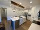 Bright kitchen features white cabinetry, quartz countertops, stainless appliances, and a large kitchen island at 312 Irving Bend Dr, Groveland, FL 34736