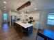 Modern kitchen with a large island, stylish pendant lighting, stainless steel appliances, and white cabinetry at 312 Irving Bend Dr, Groveland, FL 34736