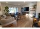 Open-concept living room with hardwood flooring, modern furniture, and sliding glass doors to a view at 312 Irving Bend Dr, Groveland, FL 34736