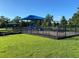 Fenced playground featuring swings and slides and a shaded rest area at 312 Irving Bend Dr, Groveland, FL 34736