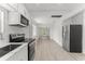Clean, modern kitchen features white cabinets, stainless appliances, and laminate flooring at 314 E Harwood St, Orlando, FL 32801