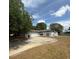 Single story home with a large driveway, well-manicured lawn, and mature trees at 337 Live Oak Blvd, Sanford, FL 32773