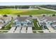 Aerial view of townhomes with blue and white exteriors, set against a backdrop of a lush green area and lake at 3600 Plainview Dr, Orlando, FL 32824