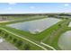An aerial view shows the neighborhood's pond and lush green area along a sunny road and highway at 3600 Plainview Dr, Orlando, FL 32824