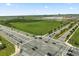 An aerial view displays an intersection along lush green areas, roadways and commercial properties at 3600 Plainview Dr, Orlando, FL 32824