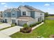 Stylish townhome featuring an attached two-car garage, a manicured lawn, and lush landscaping at 3600 Plainview Dr, Orlando, FL 32824