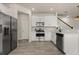 Bright kitchen boasts stainless steel appliances, white cabinets, and wood-look tile flooring at 3600 Plainview Dr, Orlando, FL 32824