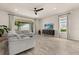 Bright living room with hardwood floors, large windows, comfortable seating, and a ceiling fan at 3600 Plainview Dr, Orlando, FL 32824